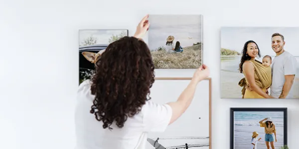 Femme disposant des photos contre un mur